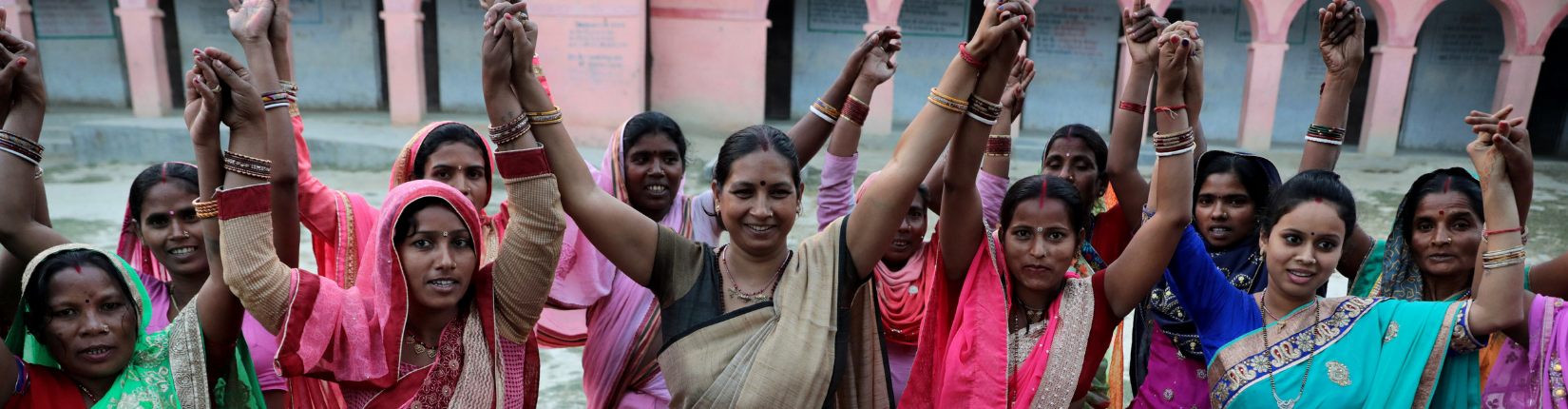 A group of women raise their hands in India