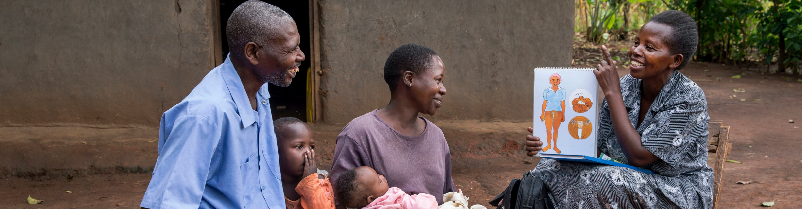 A community health worker shows a flipchart to a family in Uganda