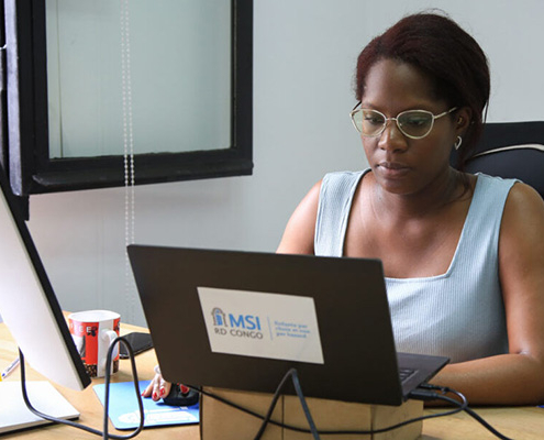 A woman working at a computer in the Democratic Republic of the Congo