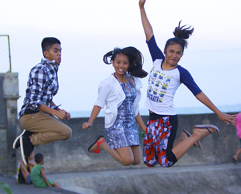 Three adolescents jumping in the Philippines