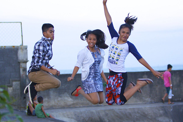 Three adolescents jumping in the Philippines