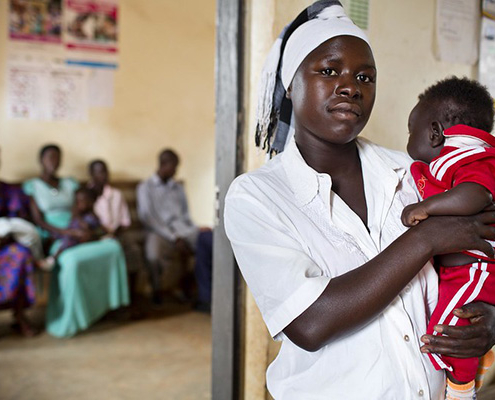 A woman is tested and treated for malaria with her new baby at a health center in Uganda
