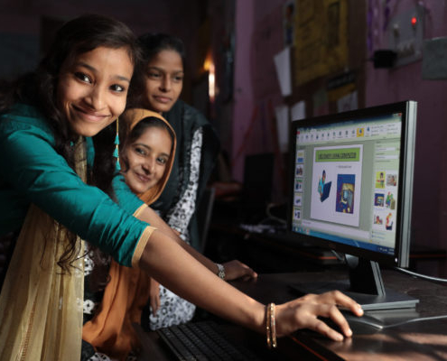Young women in India explain software to each other