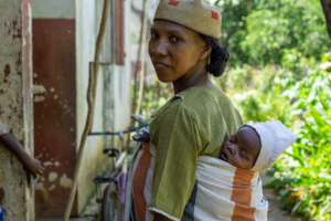 Woman carrying a baby in a sling on her back