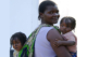 Mother carrying two young children