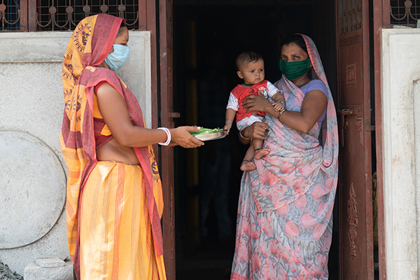 A mother receives vegetables in Gujarat