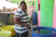 A woman outdoors near tubs of liquid in Jamaica