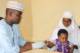A health care provider tests a young child for malaria