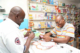 A health care provider and a man in a pharmacy in Nigeria