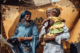 A Nigerian father holds his young daughter and smiles at his wife