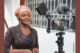 A woman standing in front of a video camera