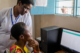 Staff at a dispensary in Tanzania speak with a woman to check her in as a new patient