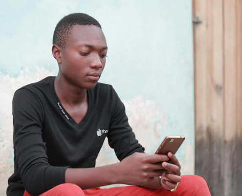 An adolescent on a mobile device in Tanzania