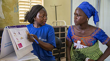 A female health worker provides reproductive health and family planning counseling to a woman