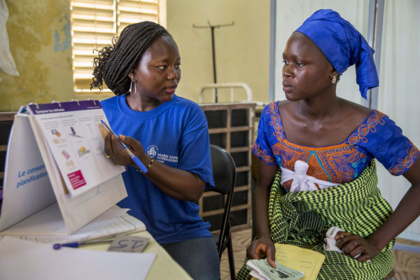 A female health worker provides reproductive health and family planning counseling to a woman in Senegal