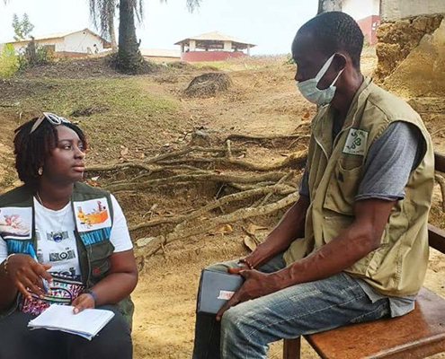 A malaria SBC specialist interviews a man in Liberia