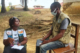 A malaria SBC specialist interviews a man in Liberia