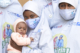 Nigerian mother with face mask on holds her baby girl