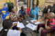 Influential community members have a discussion around a table in the DRC