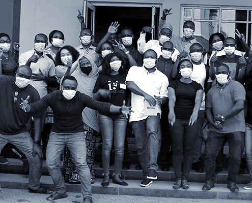 A group photo of people wearing face masks celebrating