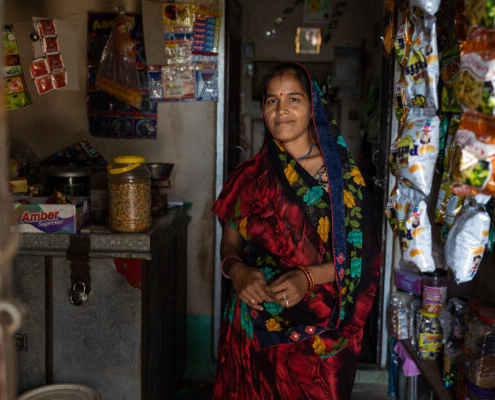 A community volunteer poses outside her grocery store in India