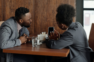 Two people sitting in café looking at a phone together