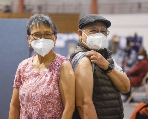 Two older adults with surgical masks and bandages after getting vaccinated in New York City