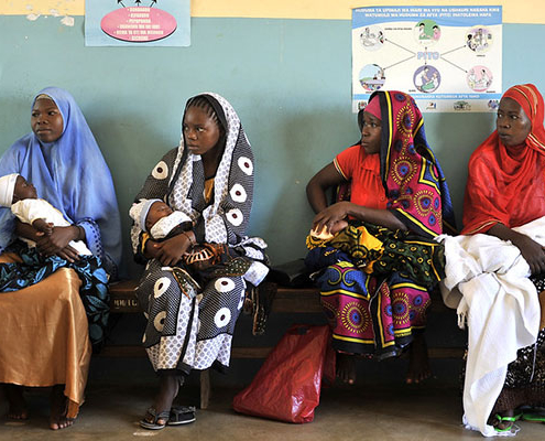Women with babies wait to receive bed nets