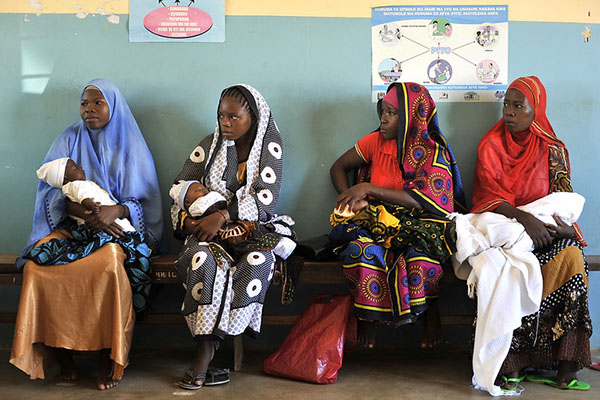 Women with babies wait to receive bed nets