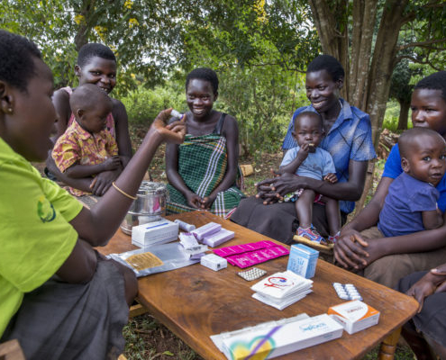 Young mothers receive family planning information from a female community health worker in Uganda