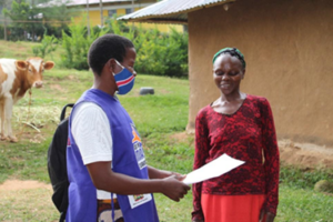 A community health worker and a woman speak outside during a home visit