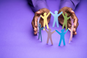 Inclusion image of hands around colorful paper dolls