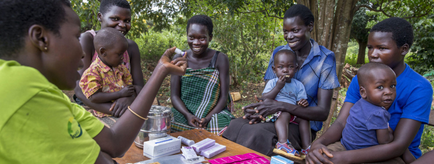 Young mothers receiving family planning information from a community health worker in Uganda