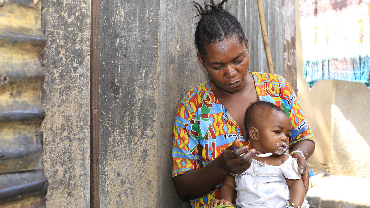 Congolese mother feeding her young child