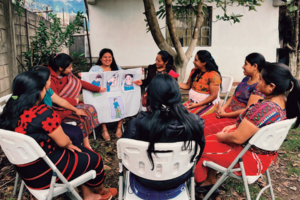 Nine Guatemalan mothers gather outside to share experiences and learn from each other