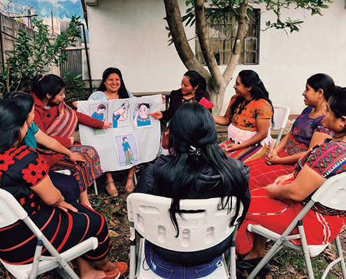 Nine Guatemalan mothers gather outside to share experiences and learn from each other