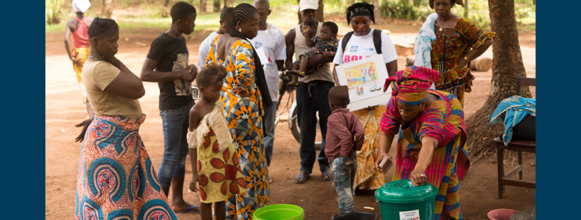 Several people gathering around a USAID wash stand as part of a campaign to rid Guinea of Ebola