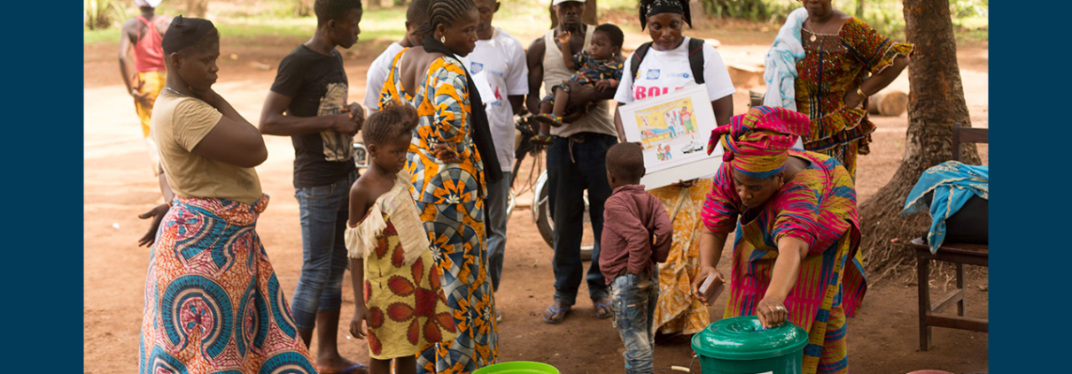 Plusieurs personnes se rassemblent autour d'un stand de lavage de l'USAID dans le cadre d'une campagne visant à débarrasser la Guinée d'Ebola