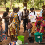 Plusieurs personnes se rassemblent autour d'un stand de lavage de l'USAID dans le cadre d'une campagne visant à débarrasser la Guinée d'Ebola