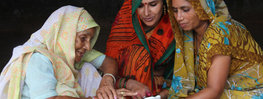 Three Indian women looking at a smartphone
