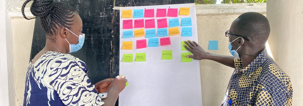 A woman and a man work with post-it notes during an HCD workshop in Kenya