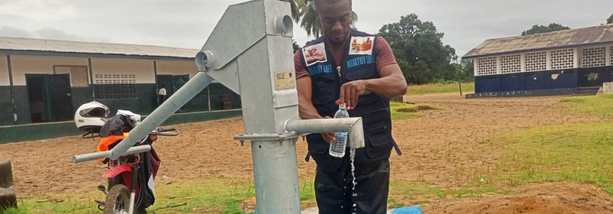 A man collects water for testing in Liberia