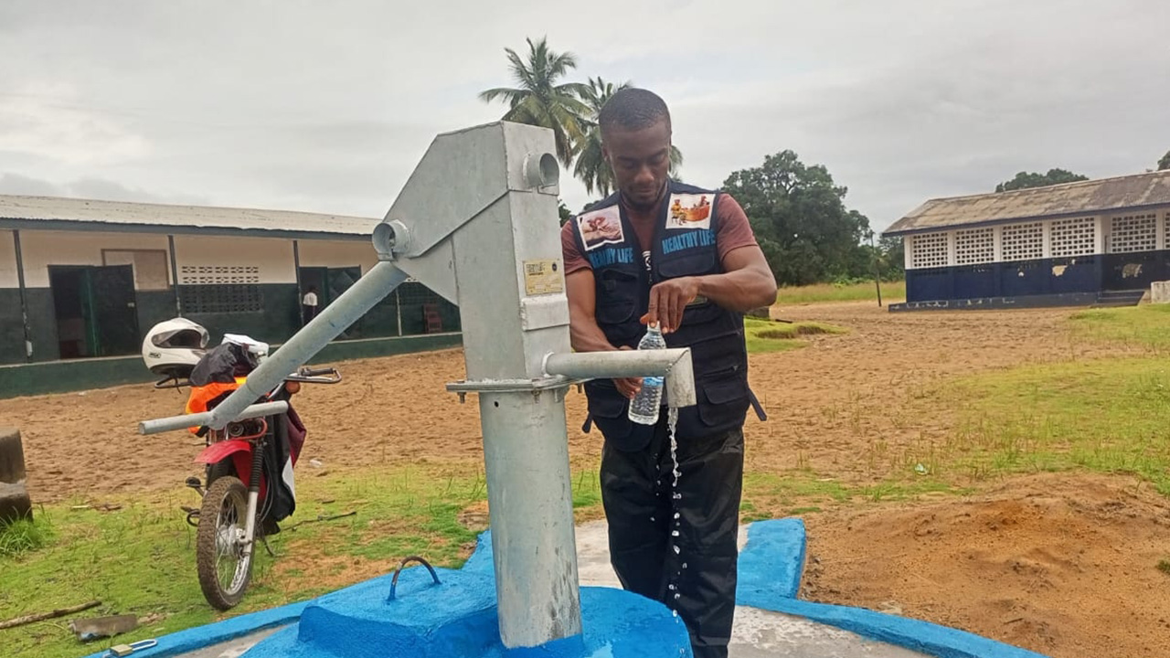 A man collects water for testing in Liberia