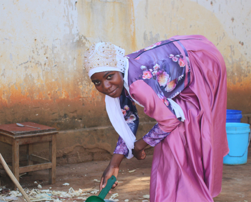 Young woman in Malawi helping with household chores