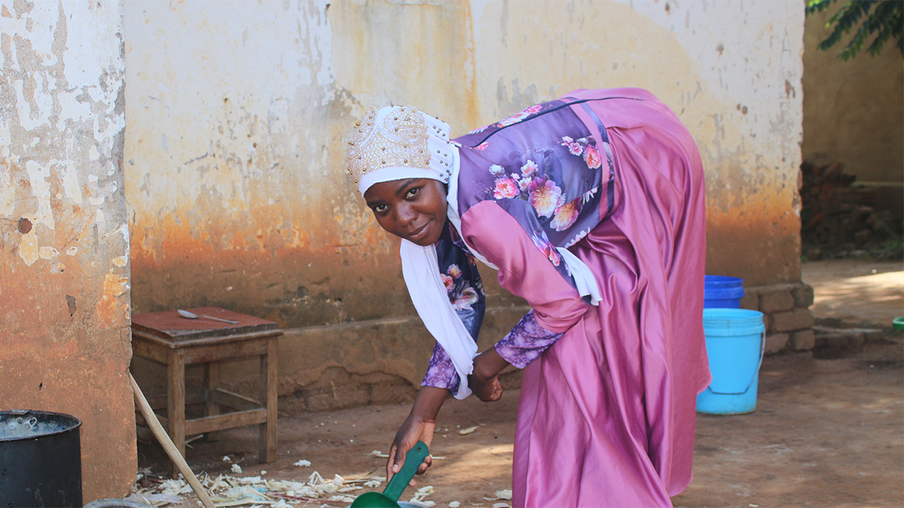 Young woman in Malawi helping with household chores