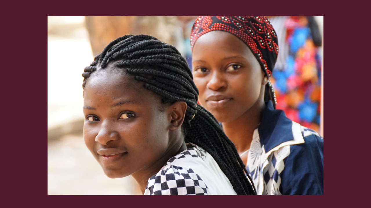 Two women wait for health services outside a health center in Mozambique