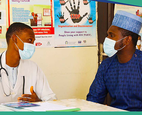 Male healthcare worker counseling male patient in a vaccination clinic