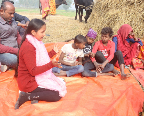 Young girl in Nepal speaking to a group of people during a community meeting.
