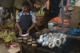 A woman selling fish at an outdoor market in Liberia