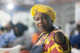 A woman, Mama Put, in her restaurant, with a concerned look on her face.